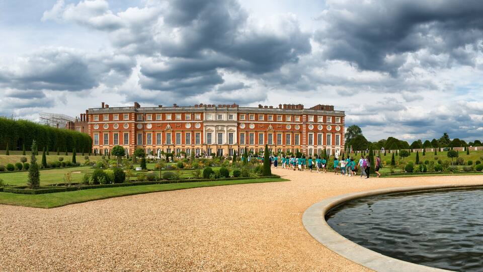 A historic building with a fountain in a formal garden.