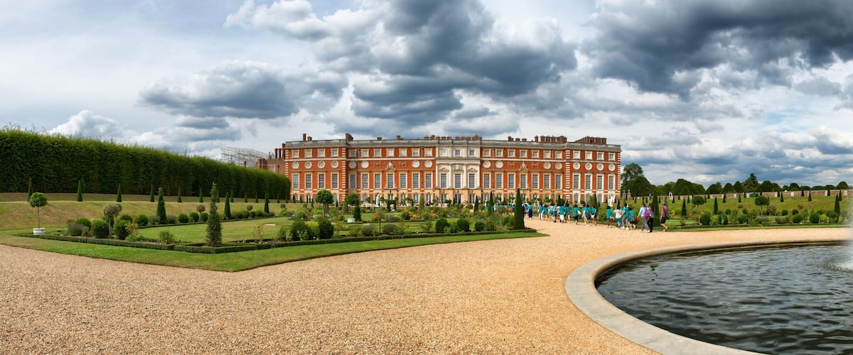 A historic building with a fountain in a formal garden.