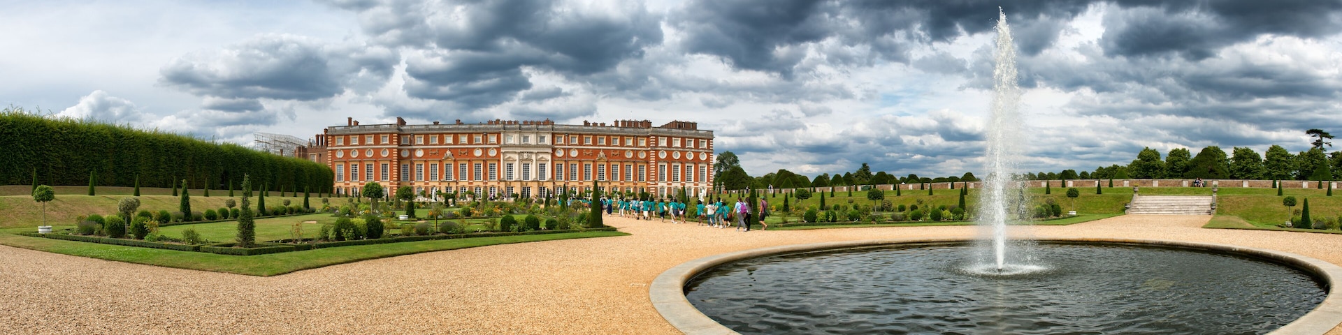 A historic building with a fountain in a formal garden.