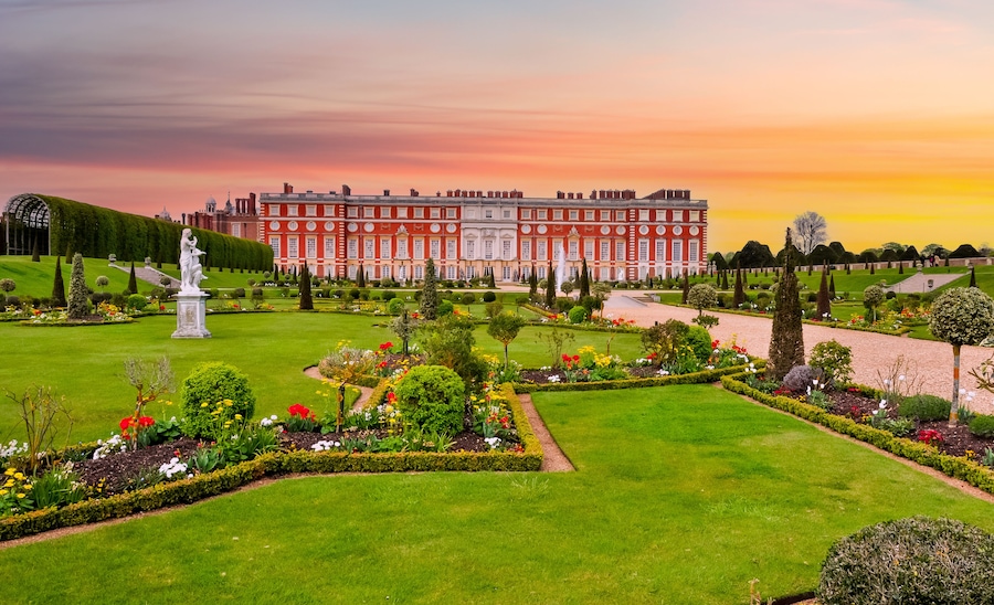 Un magnifique palais, dotĂ© dâun jardin magnifiquement entretenu, avec une statue, des haies taillĂ©es avec soin et une grande variĂ©tĂ© de fleurs aux couleurs vives.