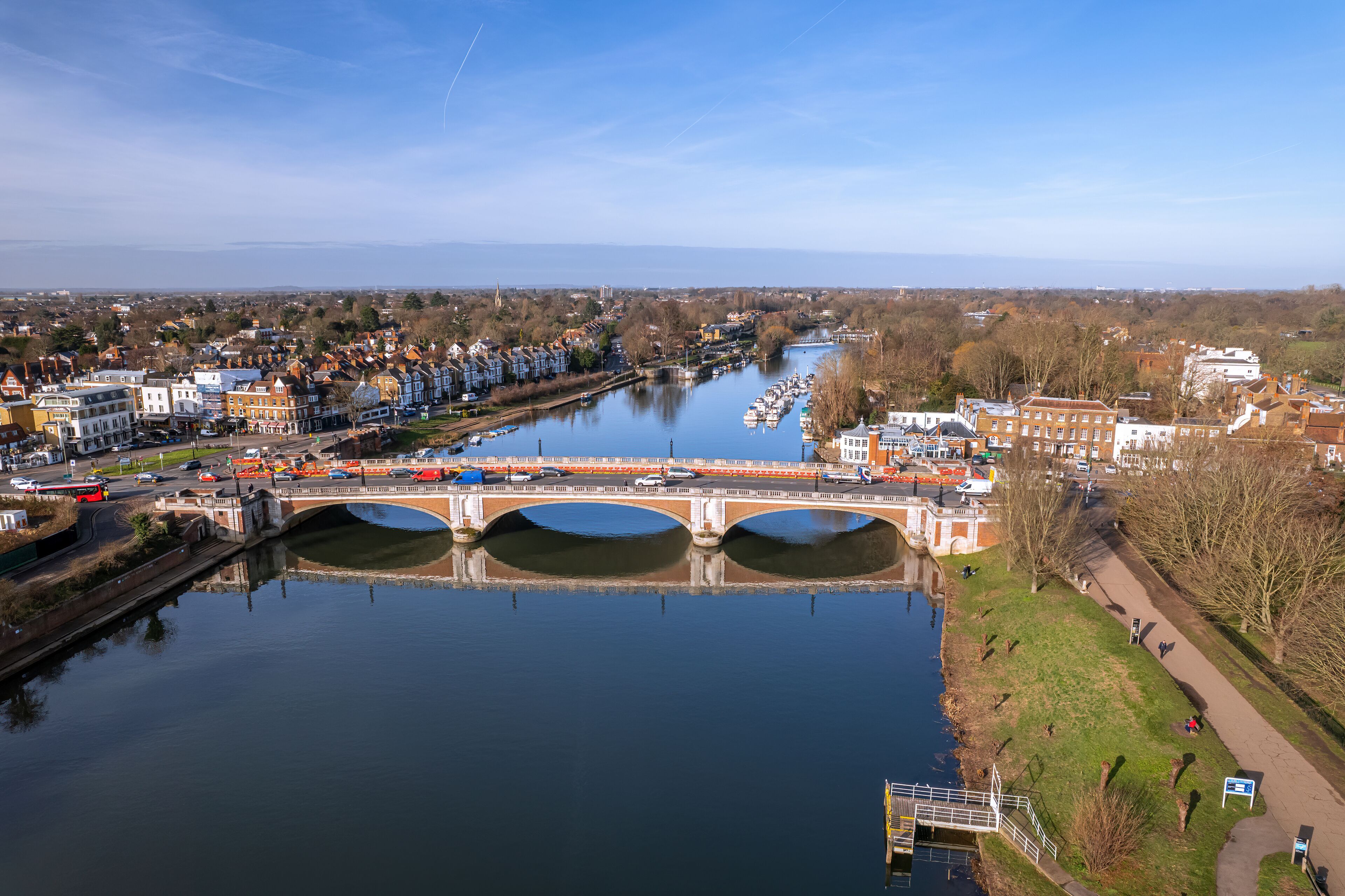 The drone aerial view of Hampton Court bridge and Thames river. Hampton Court Bridge crosses the River Thames in England between Hampton, London and East Molesey, Surrey.