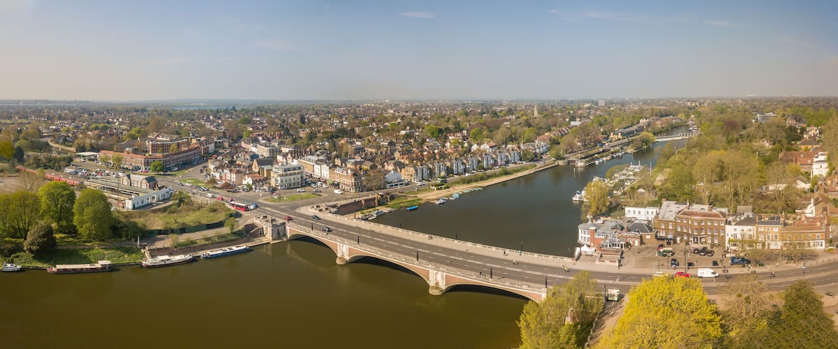 A river with a bridge, a town with historic buildings, and a body of water.