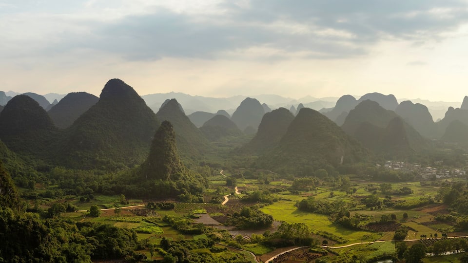 A mountainous landscape with terraced fields and a small village.