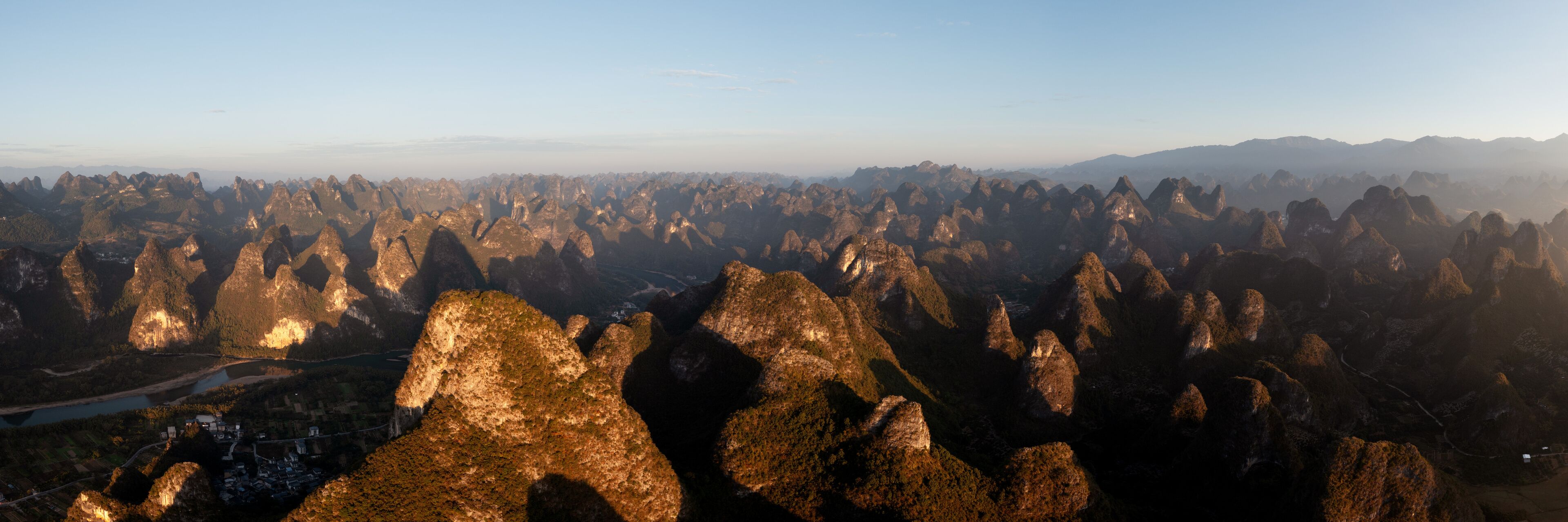 Un paisaje montañoso con numerosos picos afilados y un río serpenteando por el valle.