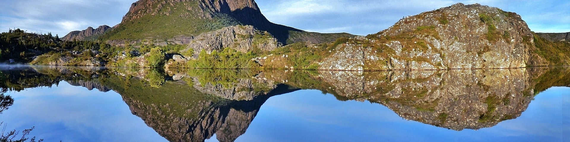 Then the top of Little Horn peeps up on the horizon, maybe I’m getting close I think. Within another 20 metres the whole purpose of the excursion becomes apparent. The vista before me is simply breathtaking. Twisted Lakes is but a mirror, everything I’d hoped and planned for has come to fruition.
When you come upon something as good as this, it’s overwhelming. The sheer majesty of the panorama engulfs you, its power makes you feel so humble in its presence, there’s a distinct aura of “something else”, but it’s indefinable. It’s all my grey matter can do to remind me that I’m here to actually take photos. You just don’t want to stop looking for fear that it will all go away and you’ll be denied any more pleasure; but it stays as I set up the tripod. It’s not often I put myself in the picture, but here I feel it’s a must. Then I can look at it and remember just where I sat and how good it was.
There are many angles to be had here. Faint trails indicate where other photographers have been, little flattened sections indicative of footfalls. It takes me around 15 minutes to get what I came for and then I sit down and enjoy breakfast, although “enjoy” seems like a totally inadequate verb in this case, there is a higher plane involved here, one you get to experience so few times in life.
The cloud has started to form more seriously now, as predicted, and it adds a little to the experience. Changing lens and shifting position constantly I can but hope I’ve got it covered and, even as I’m moving around, the first gentle ripples of the day’s breezes disturb the surface. Had I been here any later I would have missed it. You like to think it’s good fortune but reflect on that fact that you’ve planned it for a week, constantly following the weather patterns, in the hope that you’ll get it right and leaving early enough to avoid all the problems that occur later.
#Nature