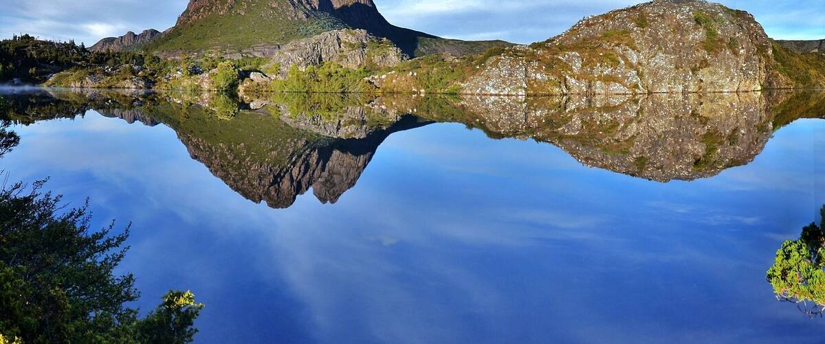 A mountain reflected in a calm lake with clear skies.