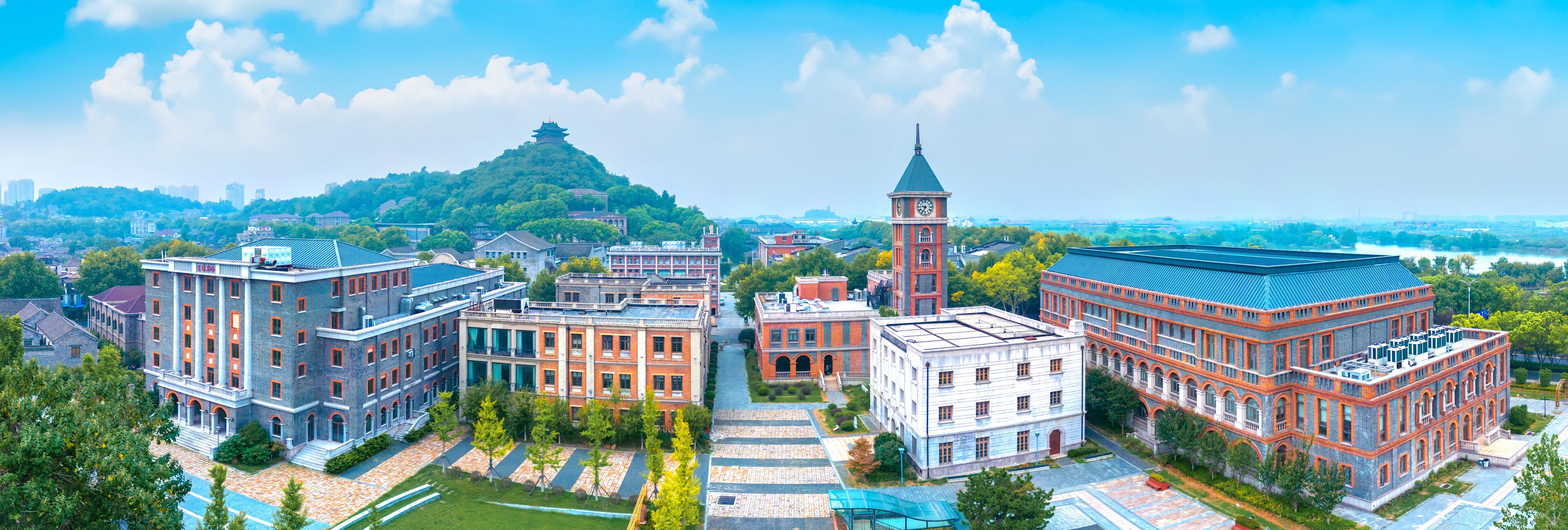 A cityscape with a prominent clock tower, a pagoda on a hill, and various historic buildings.