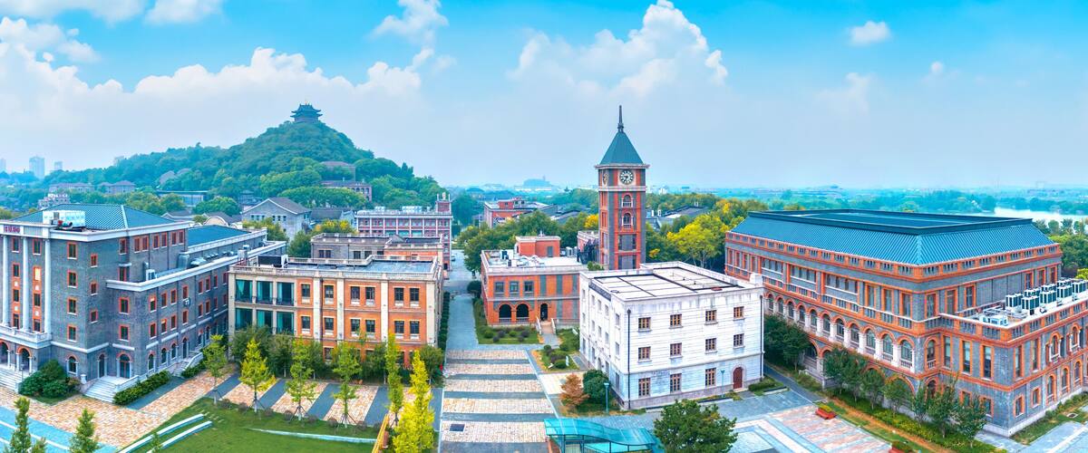 A cityscape with a prominent clock tower, a pagoda on a hill, and various historic buildings.