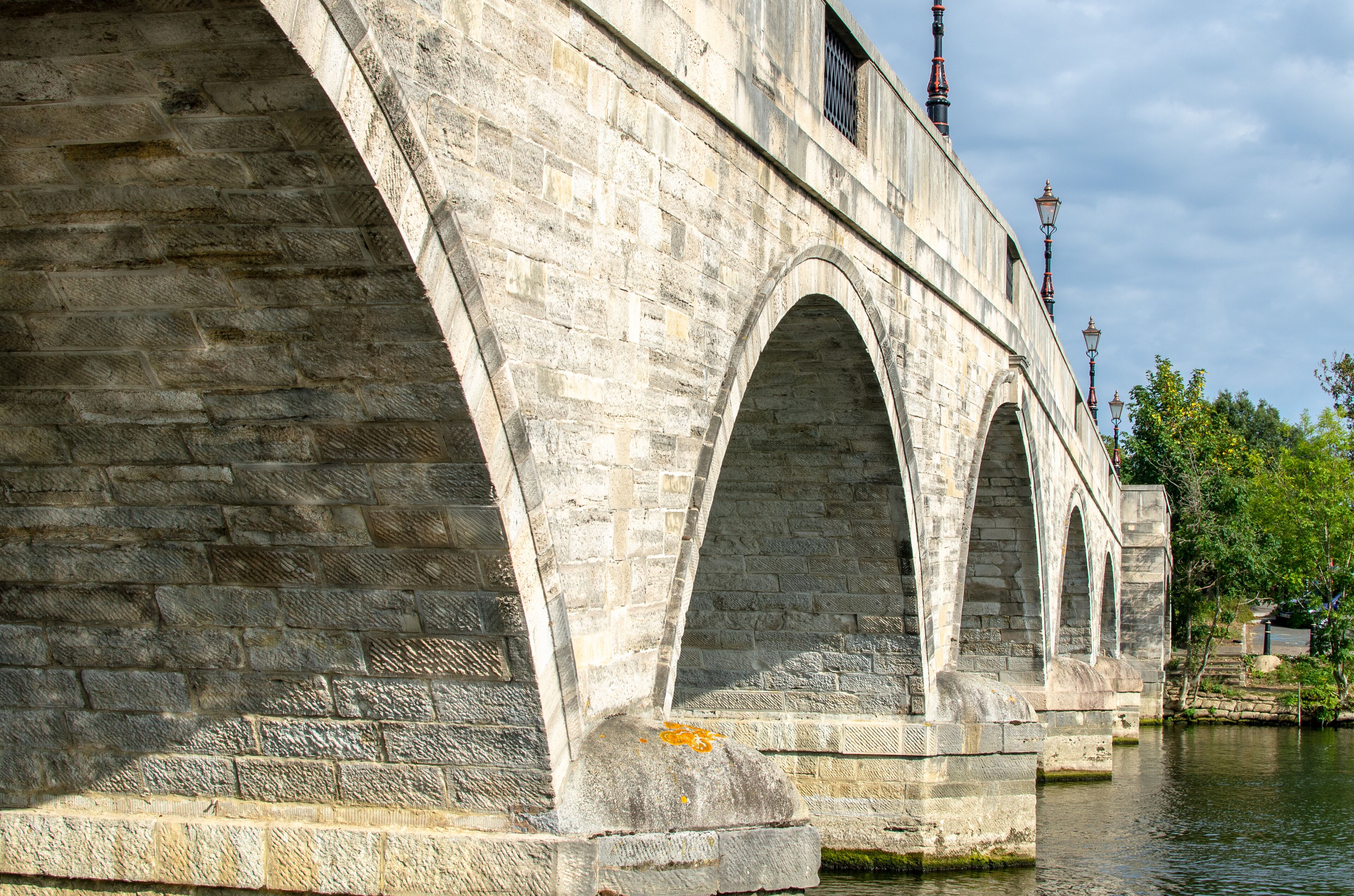 A stone bridge with multiple arches over a river.