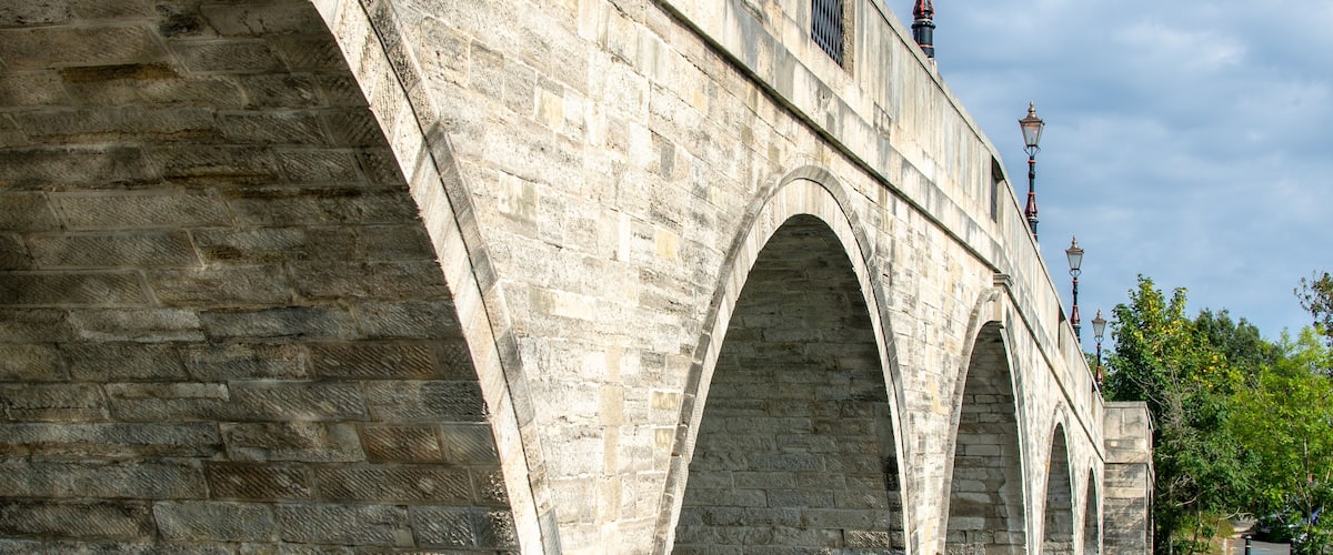 A stone bridge with multiple arches over a river.