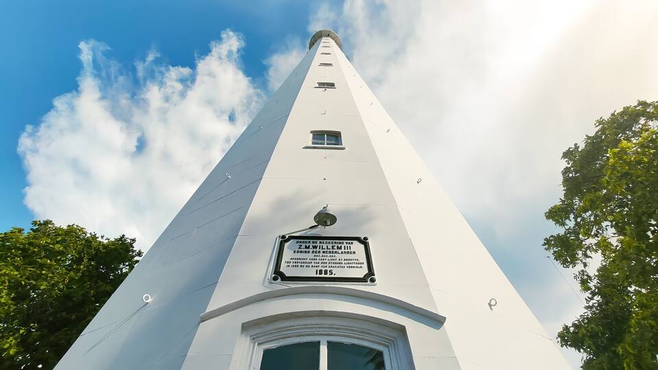 A tall white tower with a sign commemorating Z.M. Willem III.