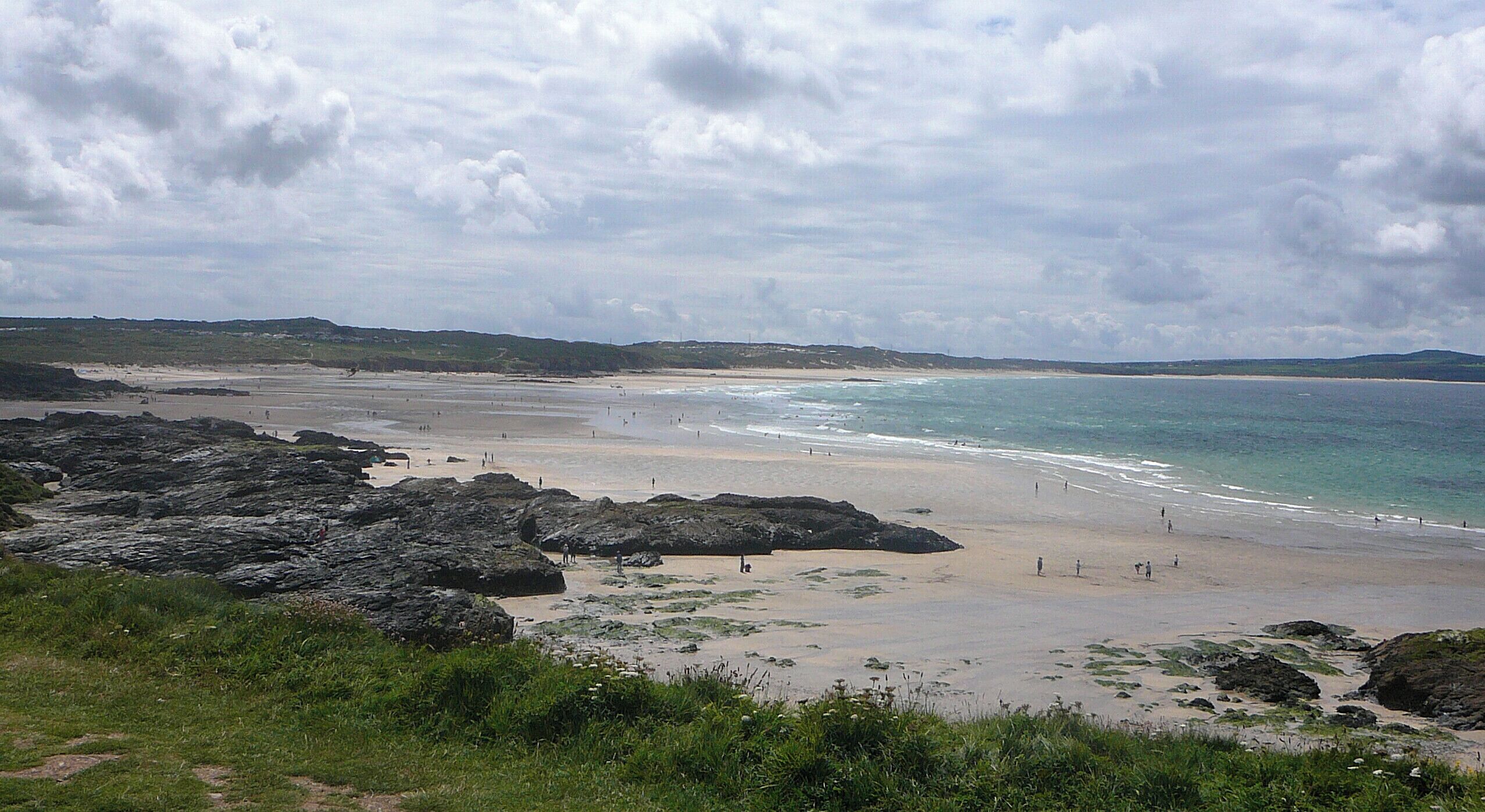 A coastal beach with rocky outcrops and a sandy shoreline.