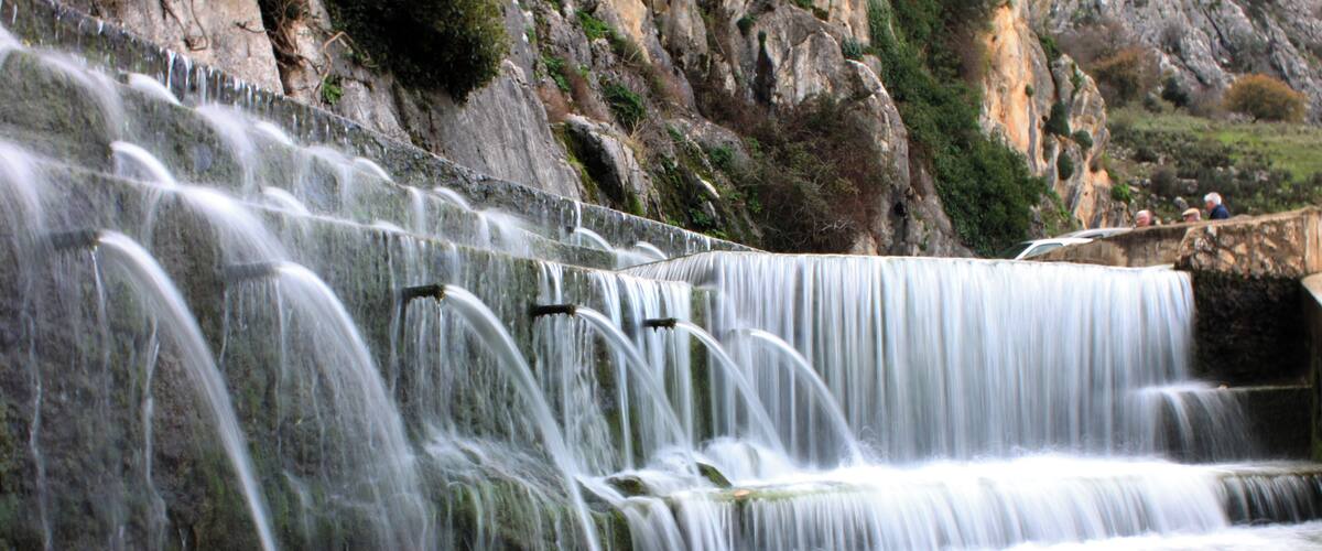 A multi-tiered waterfall with water cascading down multiple levels.