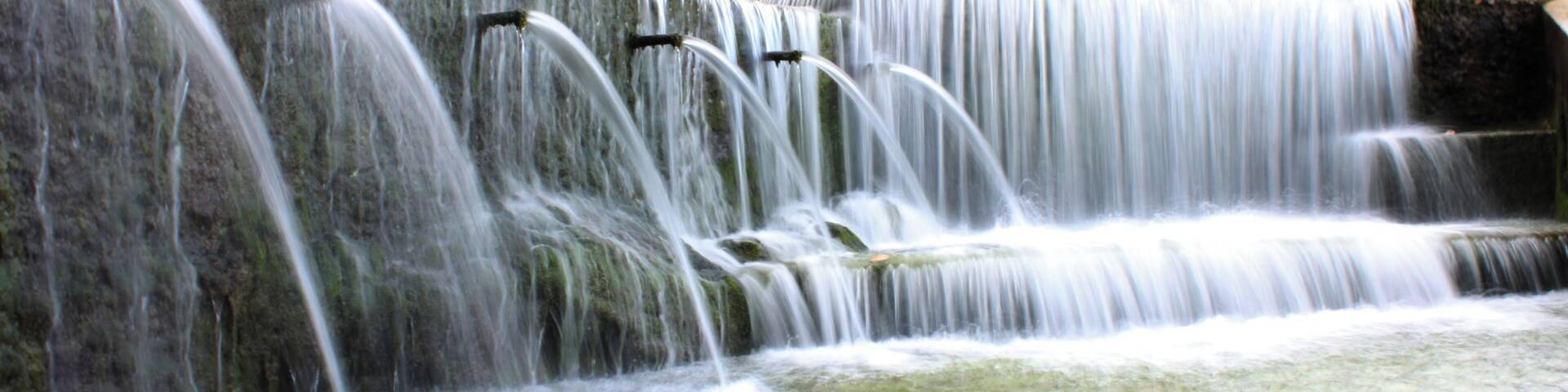 A multi-tiered waterfall with water cascading down multiple levels.