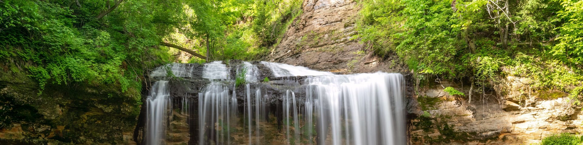 A waterfall cascading over rocks in a forested area.