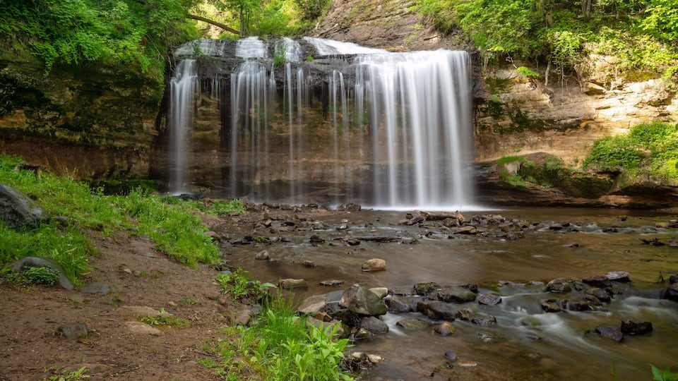 A waterfall cascading over rocks in a forested area.