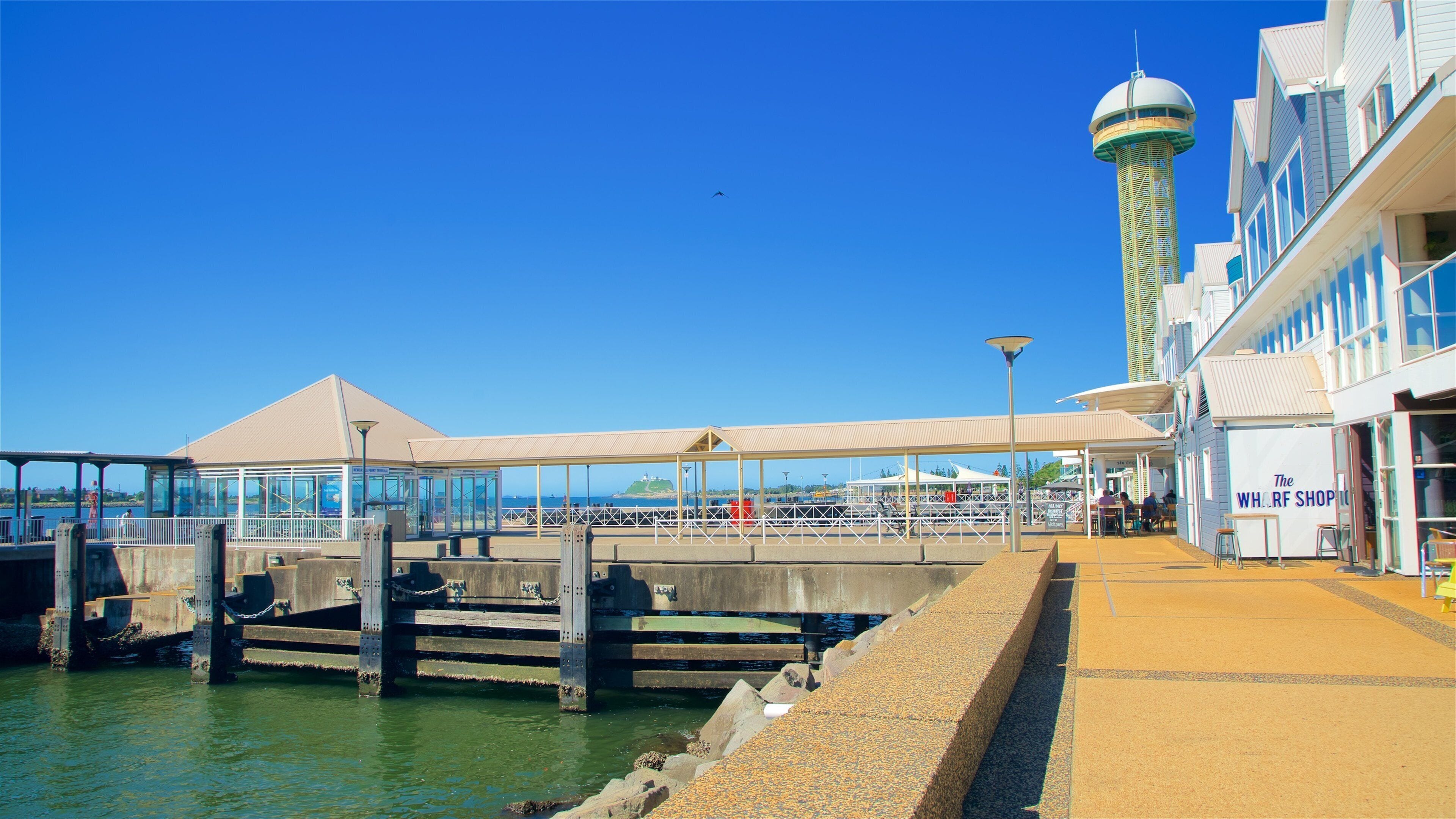 A pier with a covered walkway, a water tower, and a shop named "The Wharf Shop".