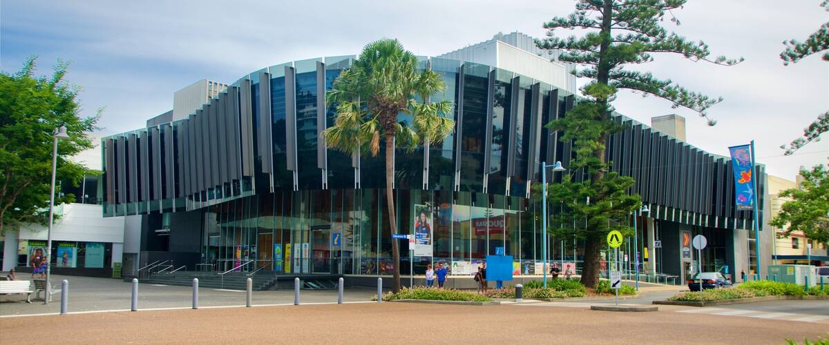 A modern building with reflective glass windows and a unique architectural design.