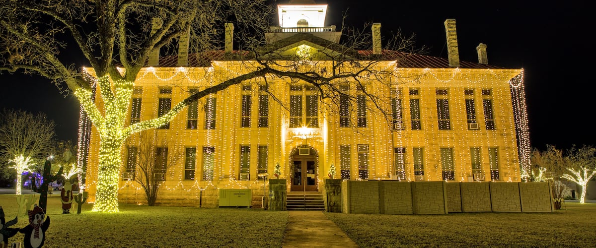 The Blanco County Court House is all decked out for the Christmas holiday season with strings of lights hanging from top to bottom on all for sides of the building. Johnson City, Texas.