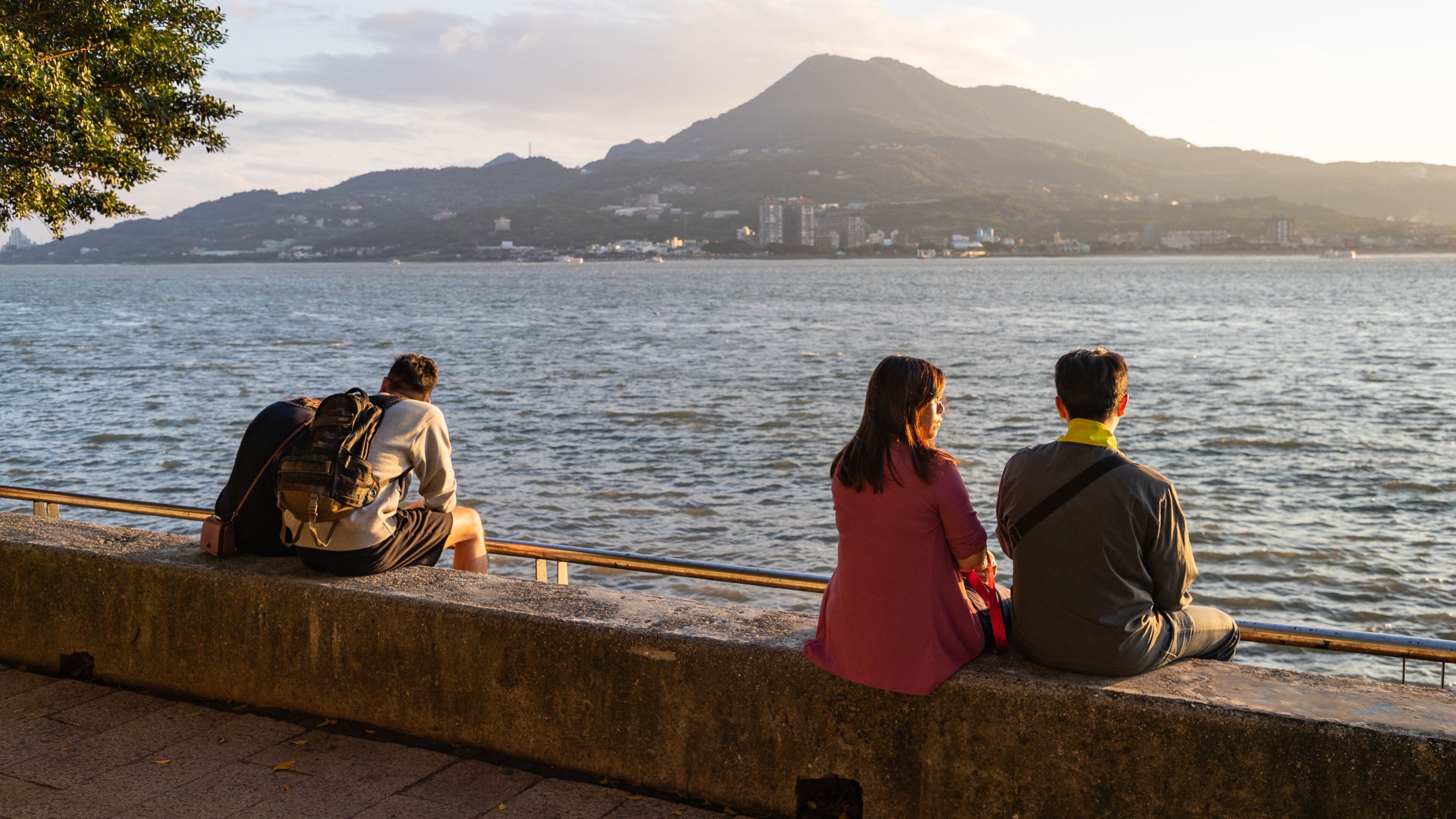 Tamsui featuring general coastal views and a sunset as well as a couple
