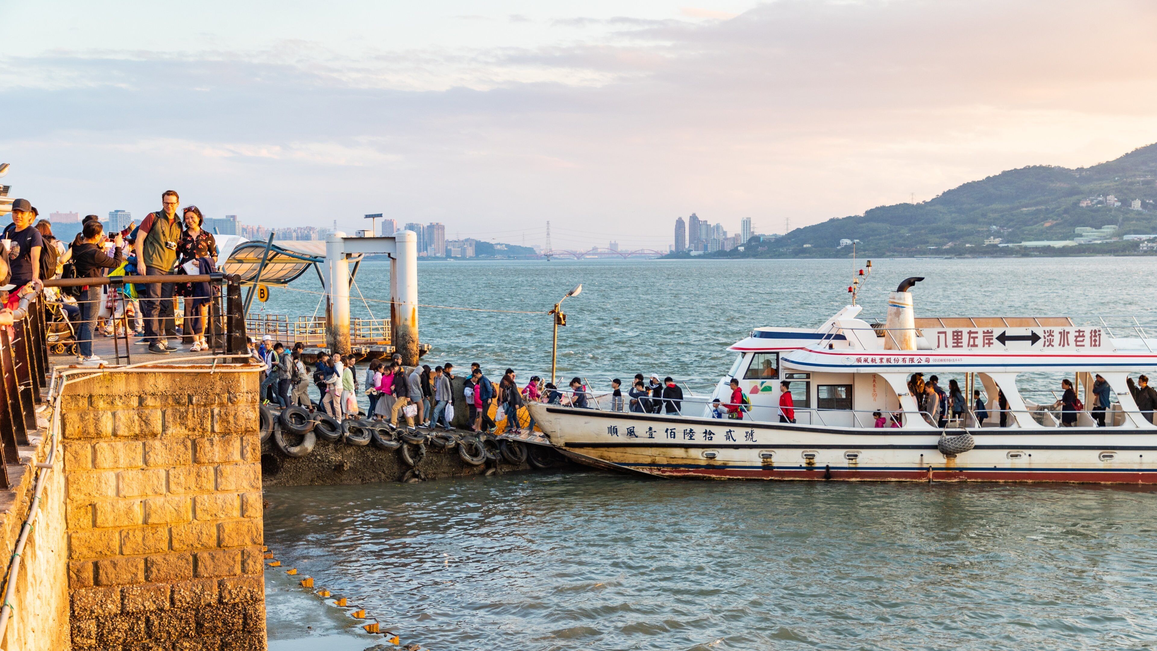 Tamsui featuring a sunset, a ferry and a bay or harbor