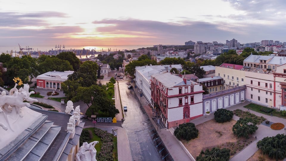A cityscape with a prominent dome and a statue of a lioness.