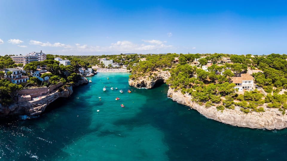 A coastal town with buildings on cliffs and a bay with boats.