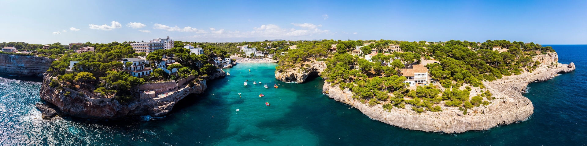 A coastal town with buildings on cliffs and a bay with boats.