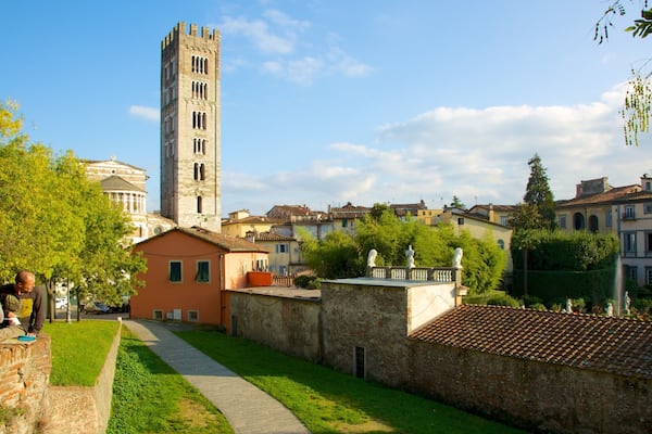 Une ville historique, caractérisée par une tour imposante, une fontaine et une végétation luxuriante.
