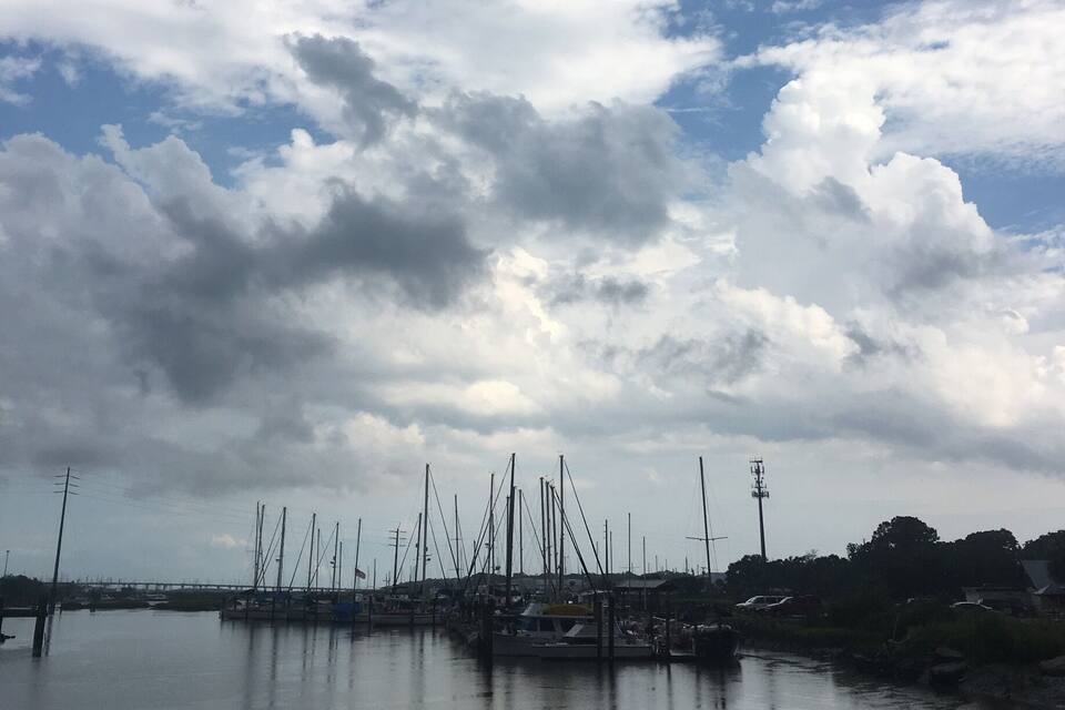 A marina with boats and masts under a cloudy sky.