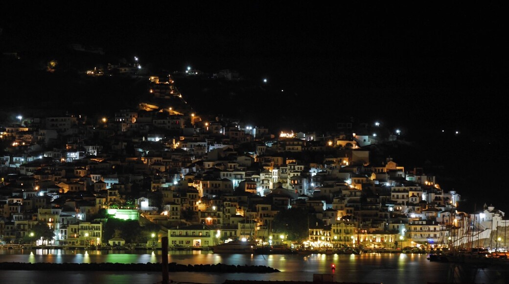 Skopelos Town by night. Skopelos is a wonderful Greek island with an authentic feel and most certainly my favourite. Reputed to be the greenest of all the Greek islands it is covered in pine forests.
It is also relatively unspoilt as it does not have an airport & is not the easiest island to get to. Like nearly all the islands however it can get busy at the height of the summer.
The main town tumbles down to the harbour through a mass of narrow streets where rubbish is still collected by mule. The tavernas abound with live music & several well known Greek musicians live and/or perform regularly here.