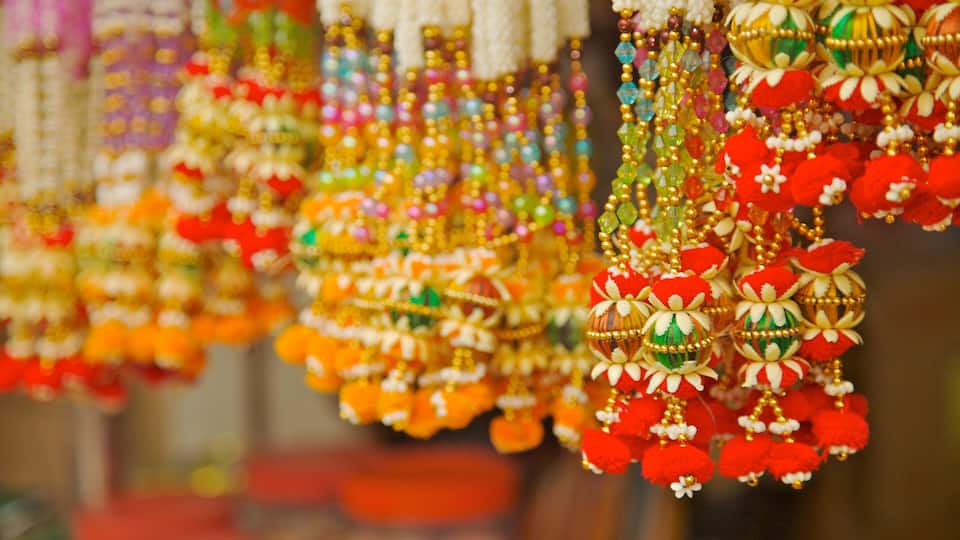 A variety of colorful beaded jewelry with red, green, and gold accents.