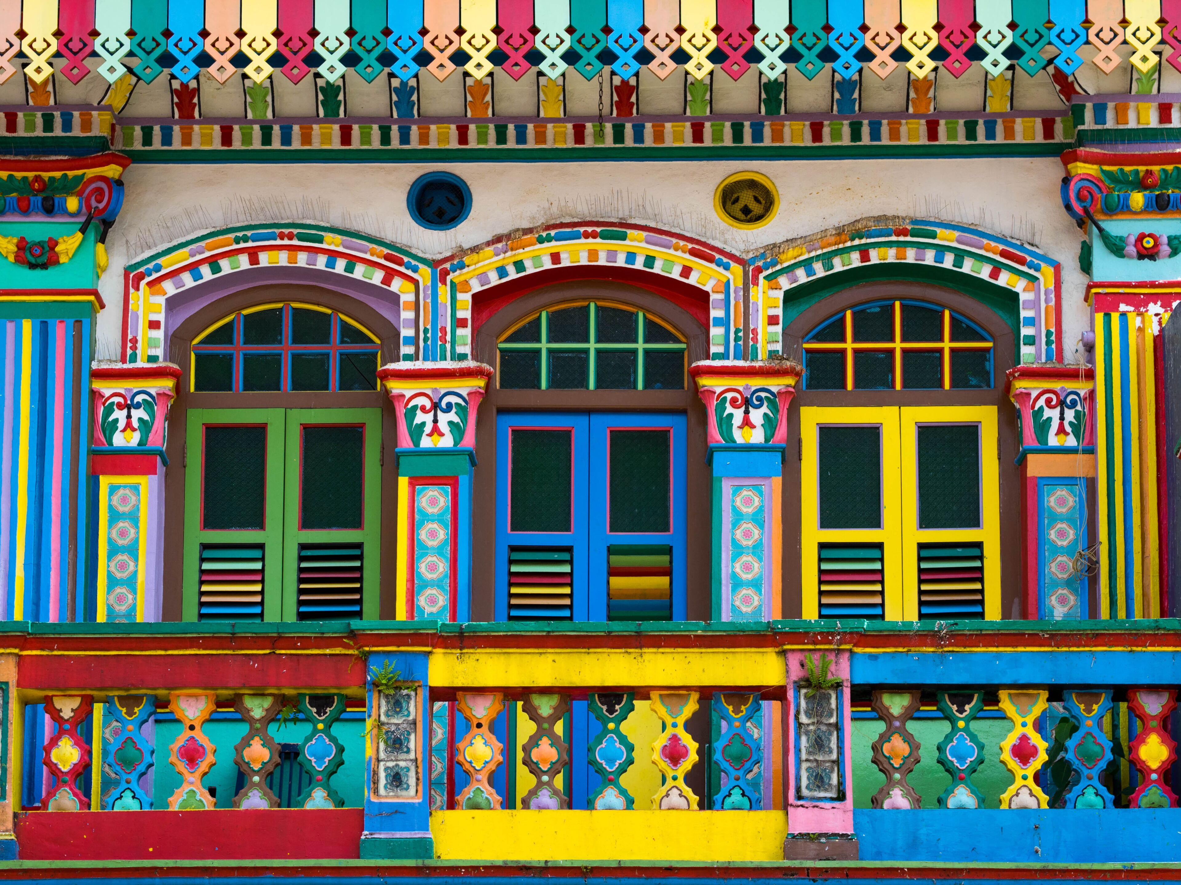 A colorful building with vibrant facades, ornate window frames, and decorative patterns.