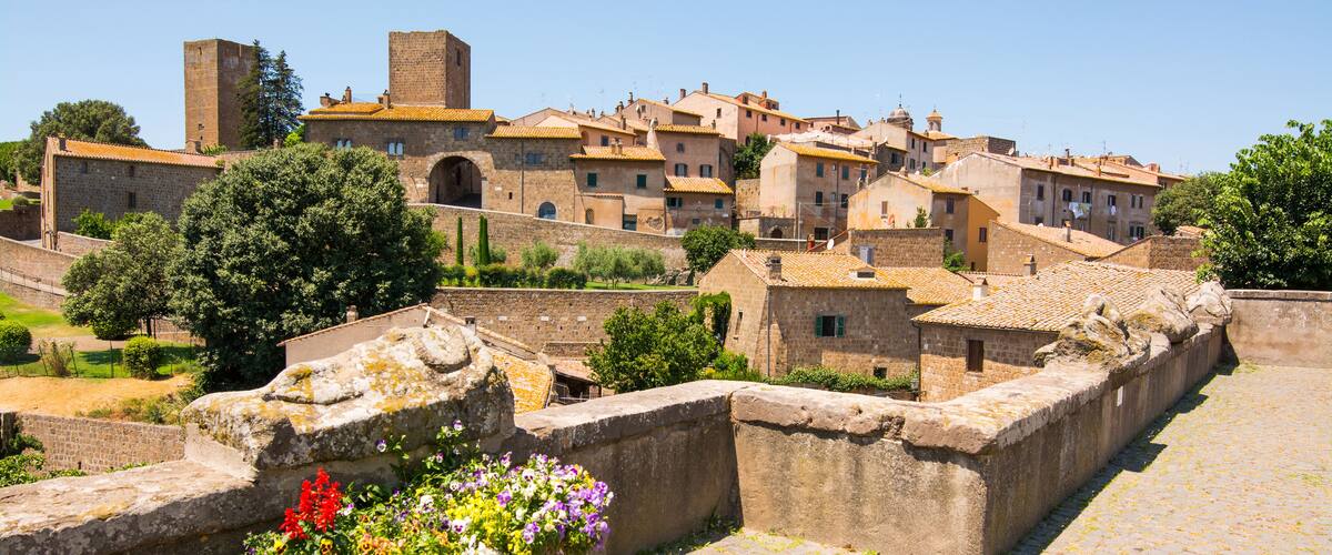 A historic town with stone walls, cobblestone streets, and traditional buildings.