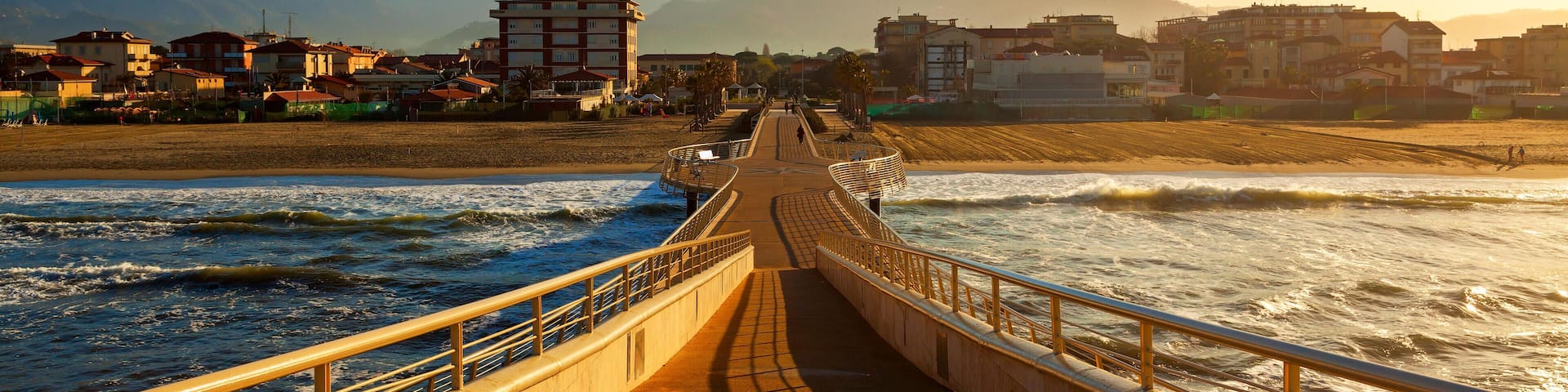 A coastal promenade with a view of mountains in the background.