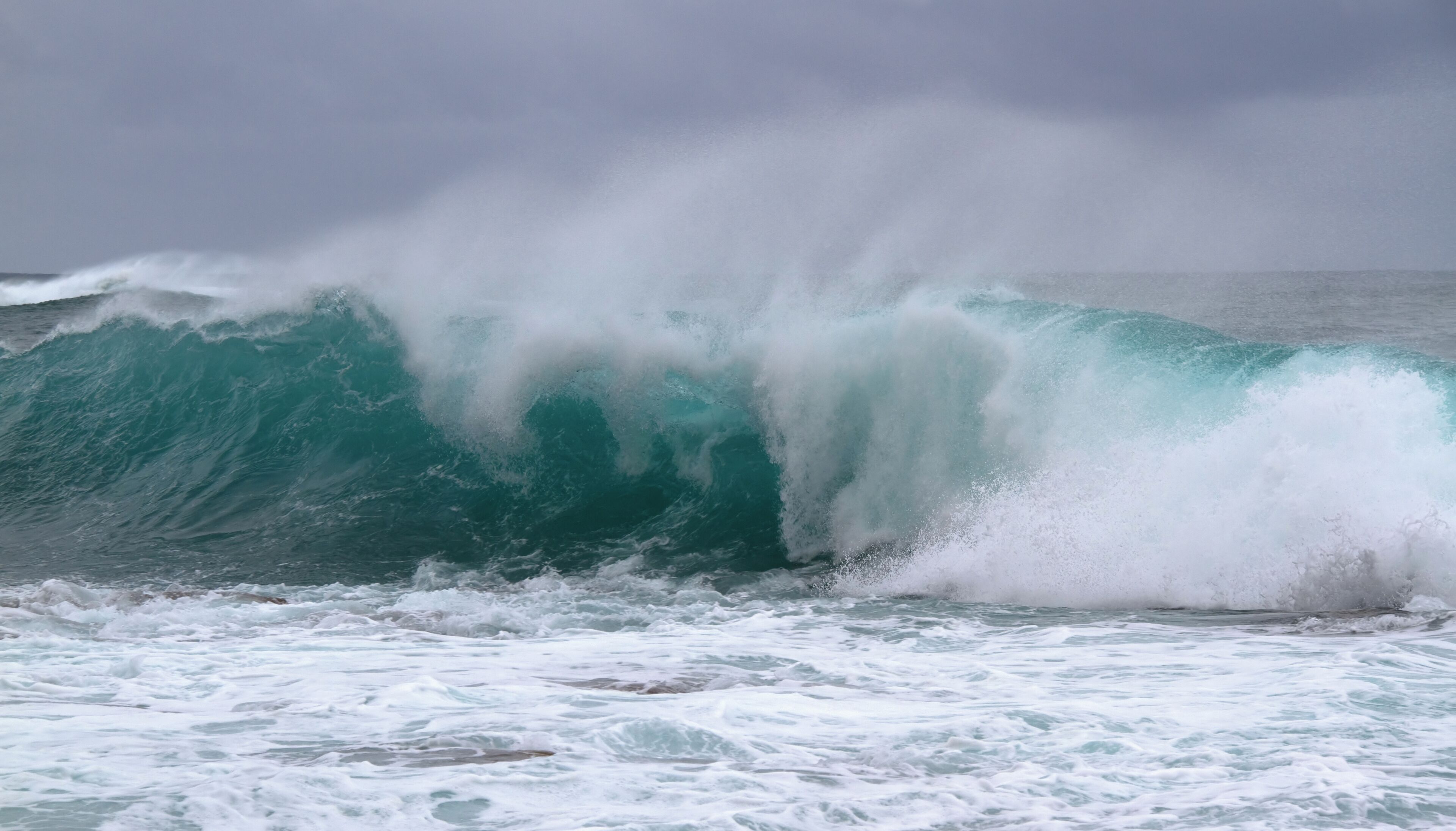 A large wave crashing onto the shore.