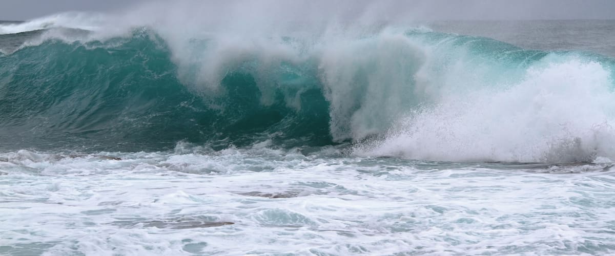 A large wave crashing onto the shore.