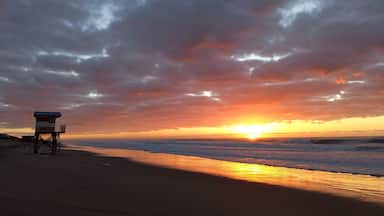 Uma praia com uma torre salva-vidas ao pôr do sol.