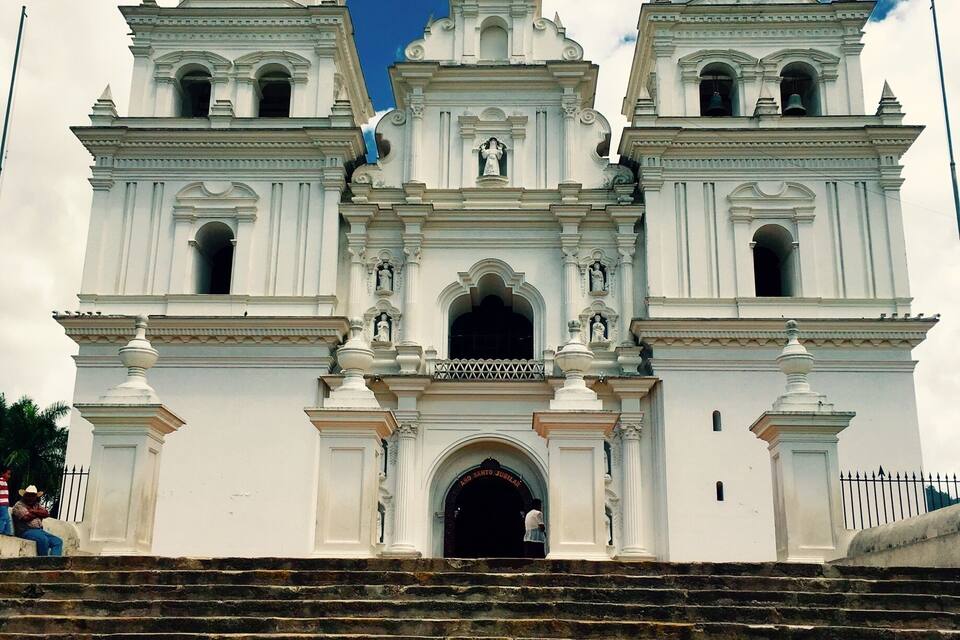 A white church with three towers and a large arched entrance.