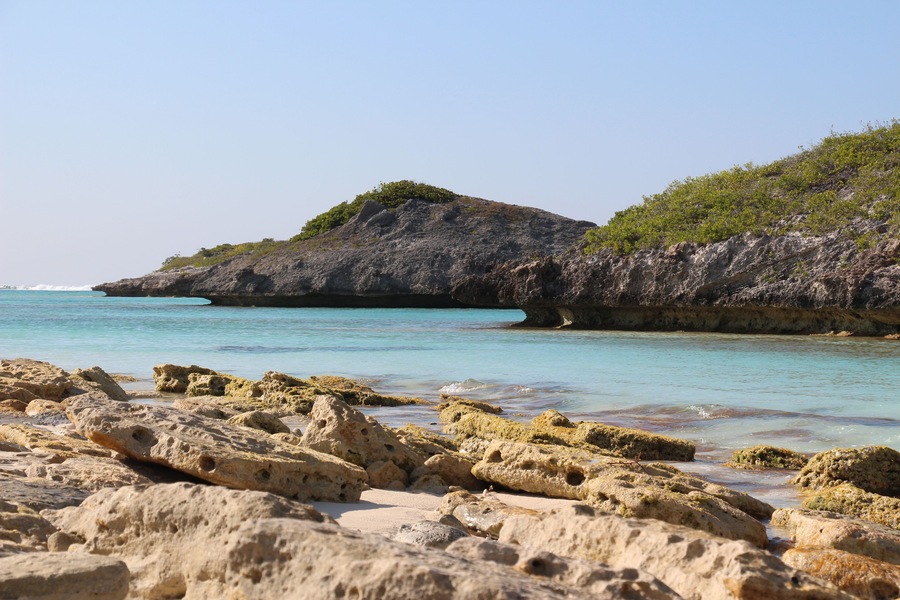 View along rocky tropical Caribbean shoreline with turquoise blue ocean in Turks and Caicos