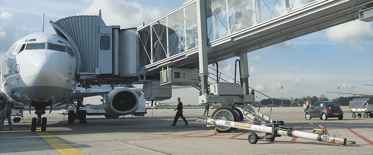 An airport jet bridge connecting to a commercial airplane.
