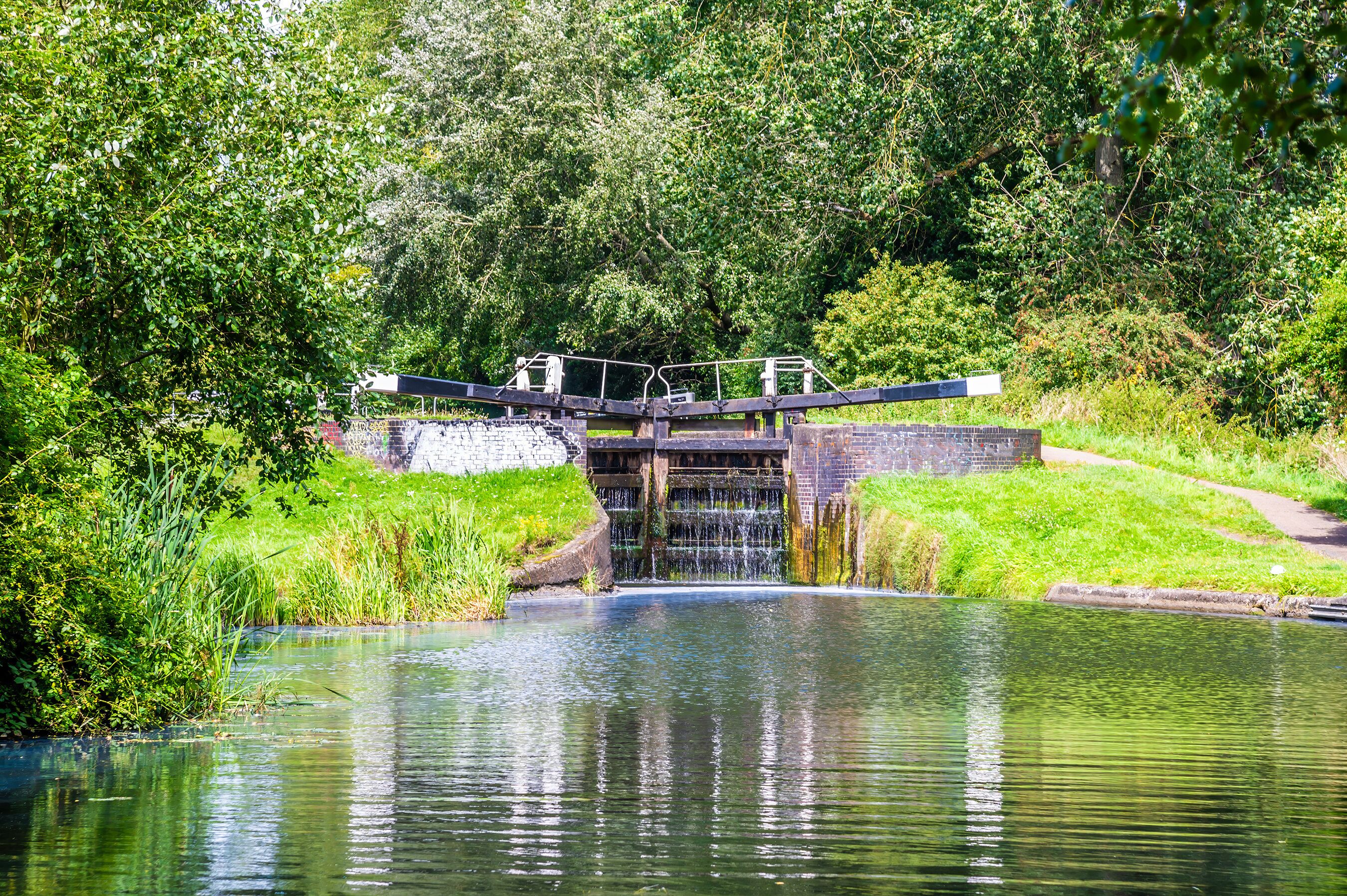 A view towards a closed lock gate filling up on the Erewash canal in summertime