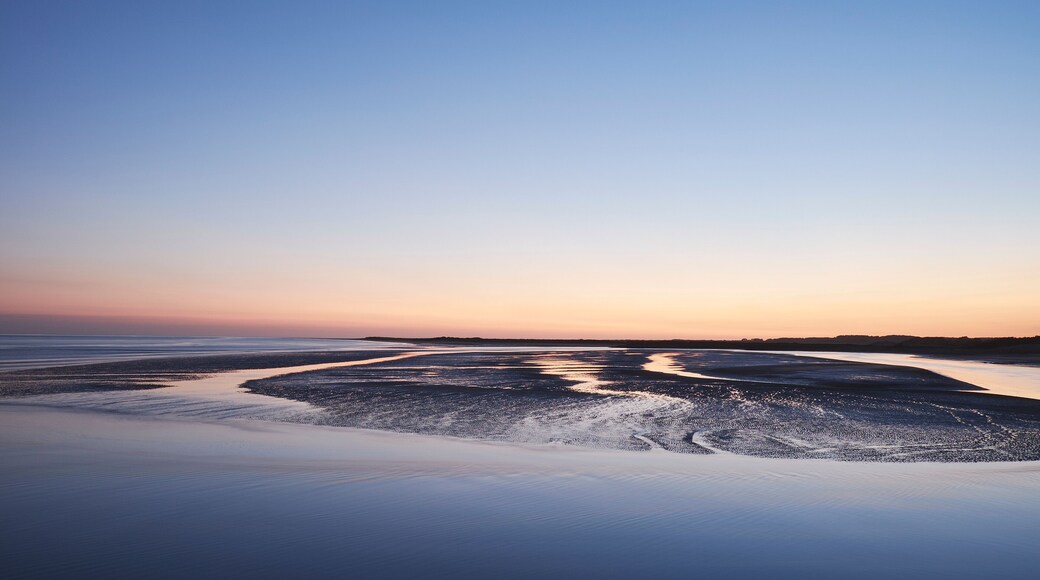 Colourful twilight sky at low tide. Burry Port, Wales, UK.