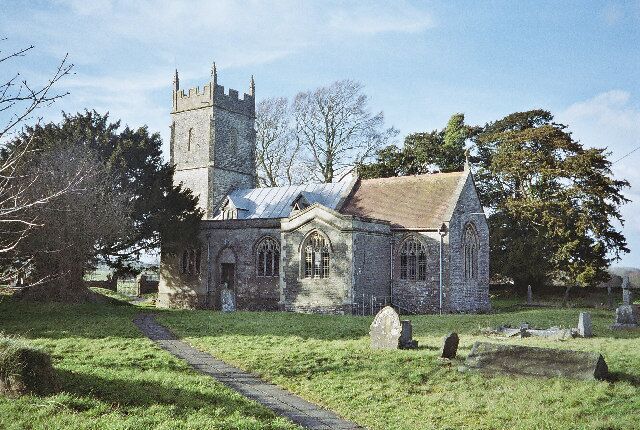 A church with a tall tower and a stone building.