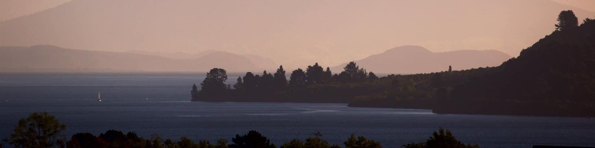 Lake Taupo which includes a sunset, a lake or waterhole and mountains
