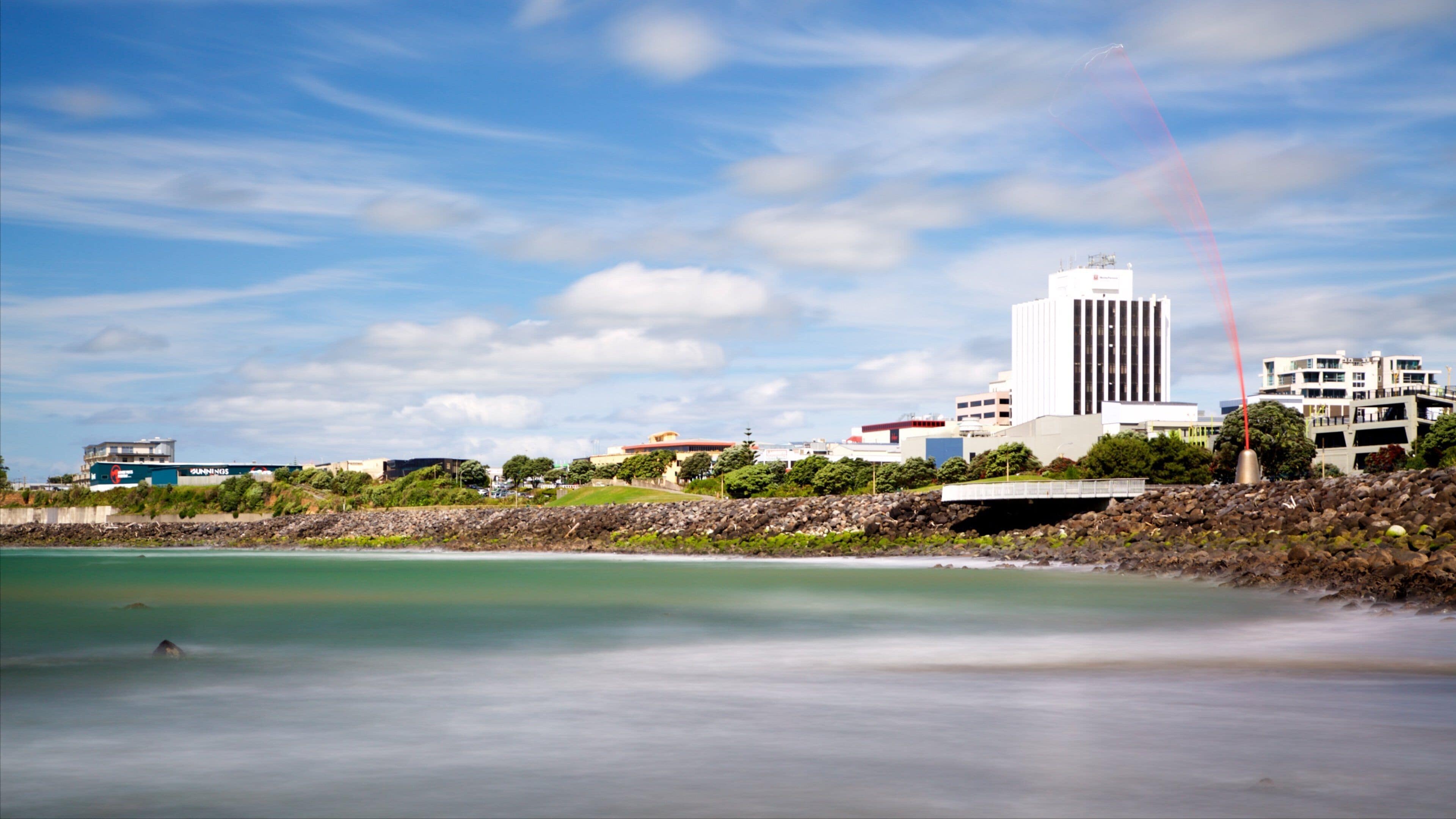 Taranaki showing a bay or harbor and rugged coastline
