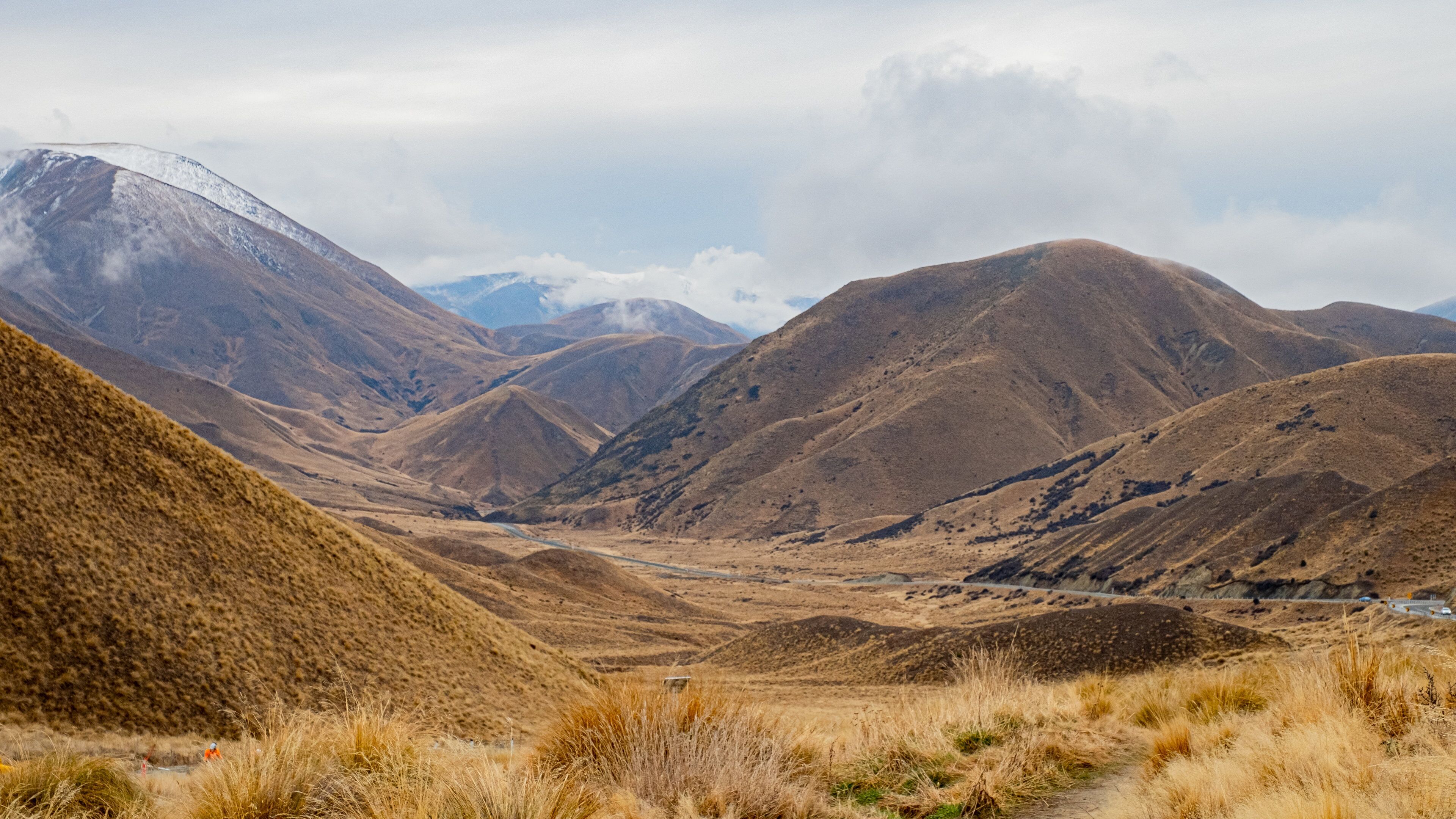 A mountainous landscape with a valley and a road.
