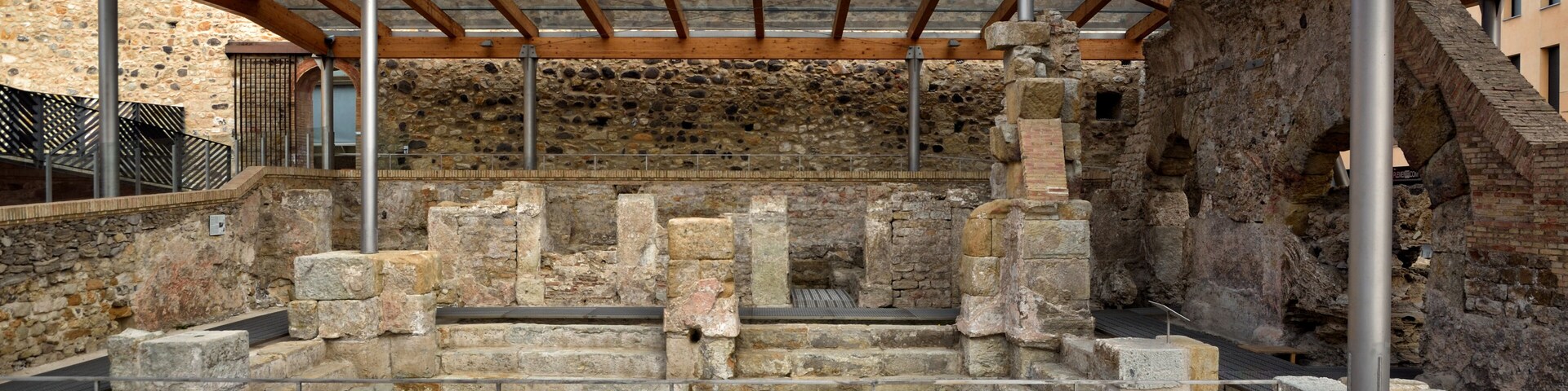 An ancient stone structure with wooden beams and metal railings.