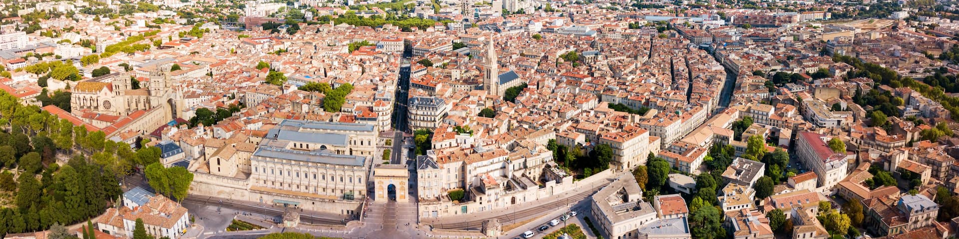 A panoramic view of a historic city with a prominent cathedral, a central square, and surrounding dense urban architecture.