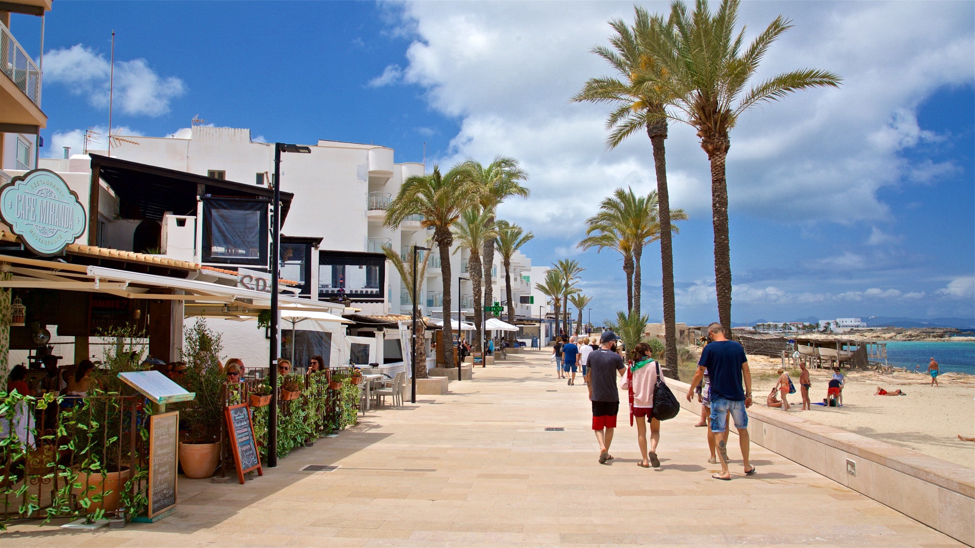Es Pujols showing a beach and a coastal town as well as a small group of people